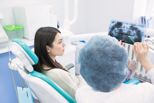 Doctor talking with patient and showing a radiograph in stomatology clinic. Dentist concept.